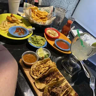 Kids chicken meal, appetizer mini tacos, quac, bean and cheese dip, salsa chips and margarita