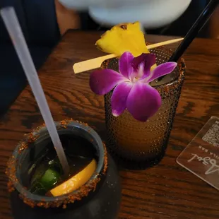a shot of a drink with a purple flower
