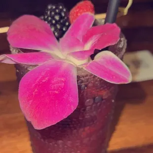a pink flower in a glass