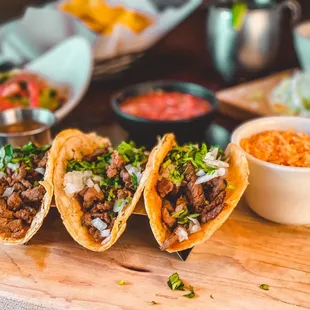 three tacos on a cutting board