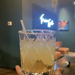 a hand holding a glass of lemonade