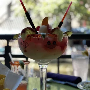 a glass of ice cream sundae with fruit garnish