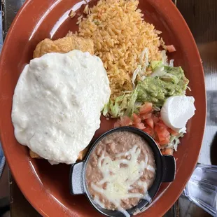 Chicken Chimichanga with rice, beans, lettuce, tomato and a dollop of sour cream