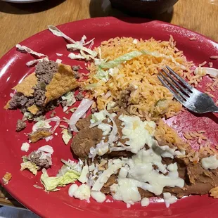 Unseasoned taco meat with refried beans and rice