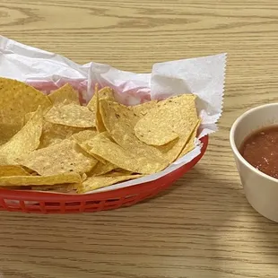 a bowl of chips and a cup of salsa