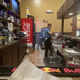 a woman preparing food in a restaurant kitchen