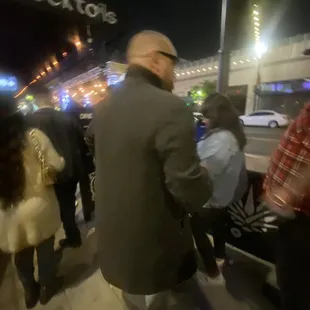 a crowd of people walking down the sidewalk