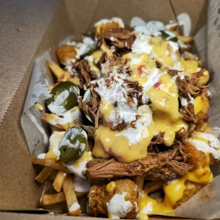 a box of fries with cheese and sauce