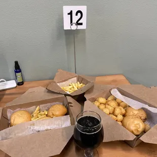 a table with three baskets of food and a glass of wine