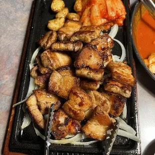 a plate of meat and vegetables with chopsticks