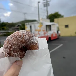  a hand holding a sugared donut