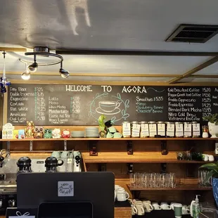 a coffee shop with a menu on the wall