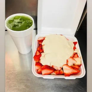 a box of strawberries and a cup of green tea