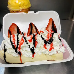 a banana split with whipped cream and strawberries