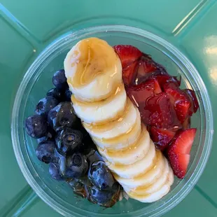 ows a bowl of fruit with bananas, strawberries, and blueberries