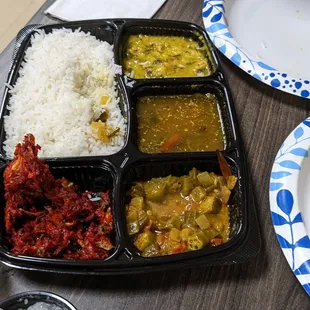 a tray of food with rice and vegetables
