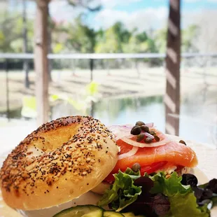 a bagel with salmon, cucumbers, and pickles