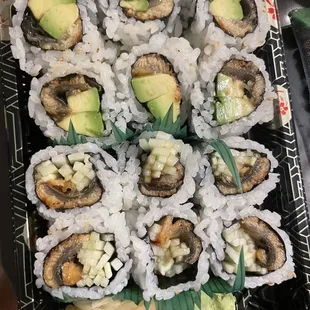 a platter of sushi rolls with avocado