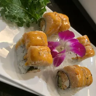 a plate of sushi with a flower