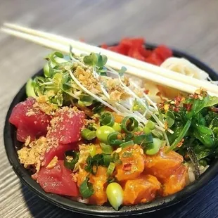 a bowl of food with chopsticks