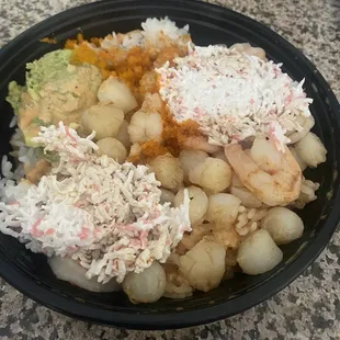 Large bowl with avocado, white rice, scallops, shrimp, and extra crab