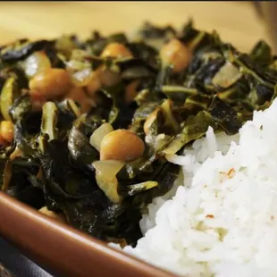 a close up of a bowl of rice and greens