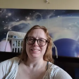 a woman with glasses smiling