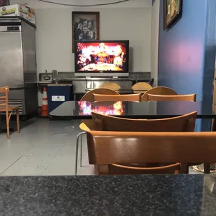 A few tables inside to sit at and a television.