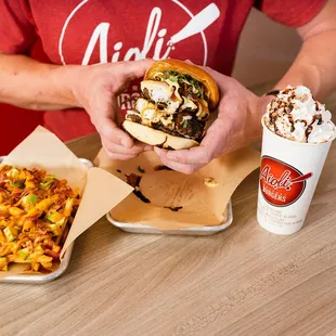 a man holding a hot dog and fries