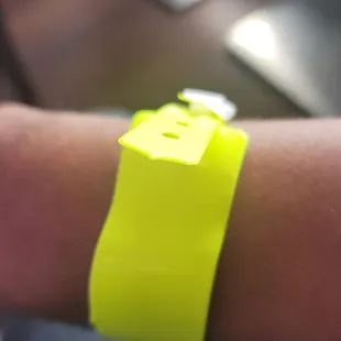 a wrist with a yellow wristband