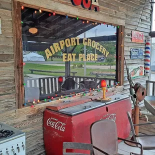 an old fashioned gas stove and chairs on a porch