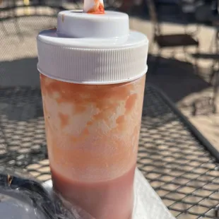 a cup of hot sauce on a table