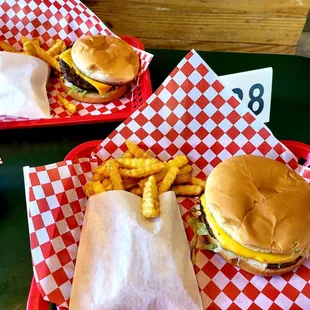 two trays of hamburgers and french fries