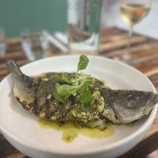 a plate of fish and a glass of wine