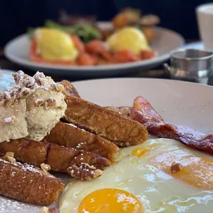 French toast with eggs and bacon. Salmon pastrami  Benedict in the background.