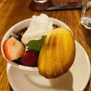 a bowl of fruit and whipped cream