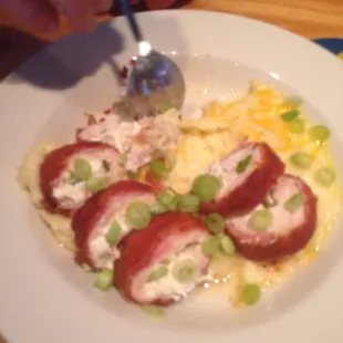 Cream cheese jalapeño stuffed chicken breast wrapped in bacon over jalapeño cheese grits I think he licked the bowl