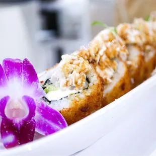 a sushi roll with a purple flower