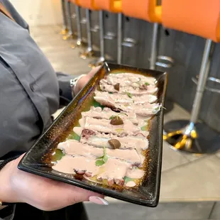 Pulpo al olivo - Pulpo en corte sashimi cubierto de una crema de aceituna botija