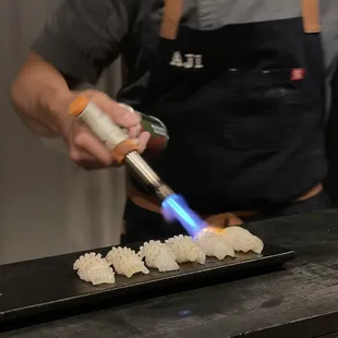 a man in an apron making sushi