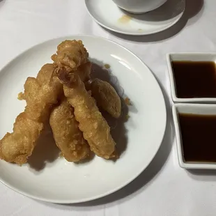 a plate of food with dipping sauces