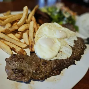 BISTEC A LO POBRE (steak topped with fried eggs and plantains, served with white rice and salad)