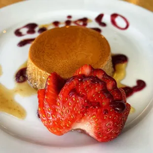 a piece of cake and a strawberry on a plate