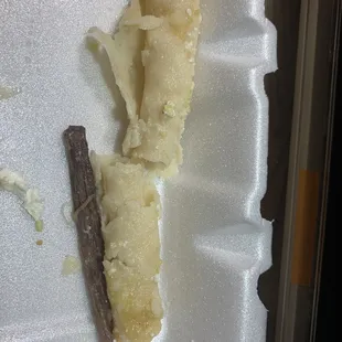 a partially eaten piece of food in a styrofoam container