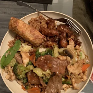 Broccoli Beef, Garlic Chicken, Happy Family, Orange Chicken and an Egg Roll... no I didn&apos;t finish it all