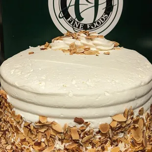 a cake with white frosting and toasted almonds