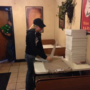 a woman opening a pizza box