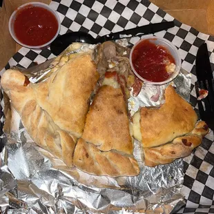 Calzone with Pepperoni, Italian Sausage, mushrooms and pineapple. One slice is already eaten. Delicious!