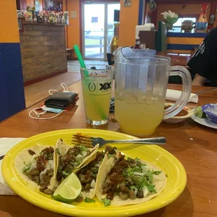 a plate of tacos and a pitcher of lemonade