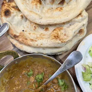 a plate of naan bread and a bowl of curry